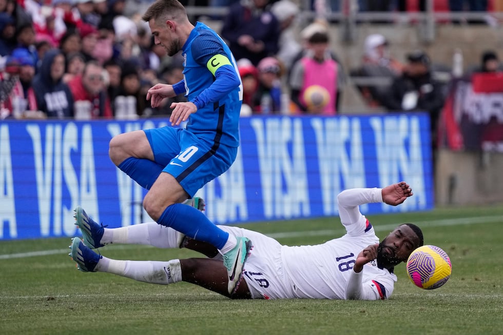 United States defender Shaq Moore (18) is tripped up as he and Slovenia midfielder Timi Max...