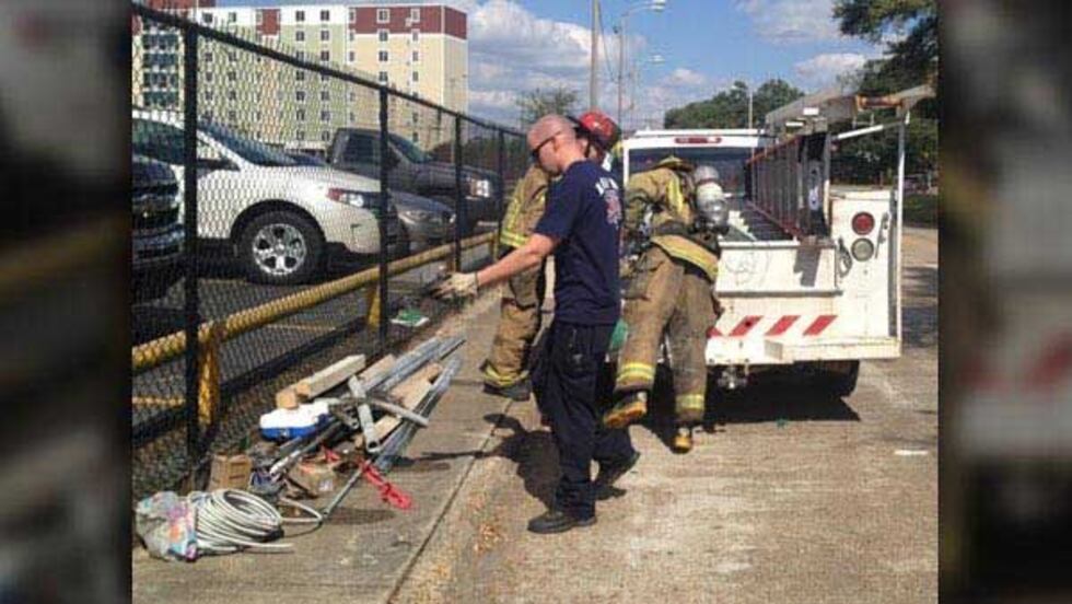 Lake Charles firefighters check a pickup truck after a small vehicle fire near the KPLC studio...