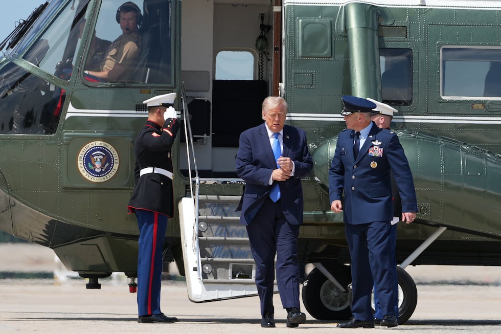 President Donald Trump walks from Marine One with Air Force Col. Christopher M. Robinson,...