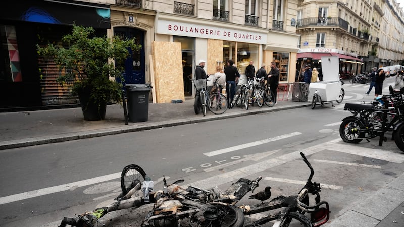 Burned electric bicycles lie on the road near a bakery after weekend protests over the cost of...