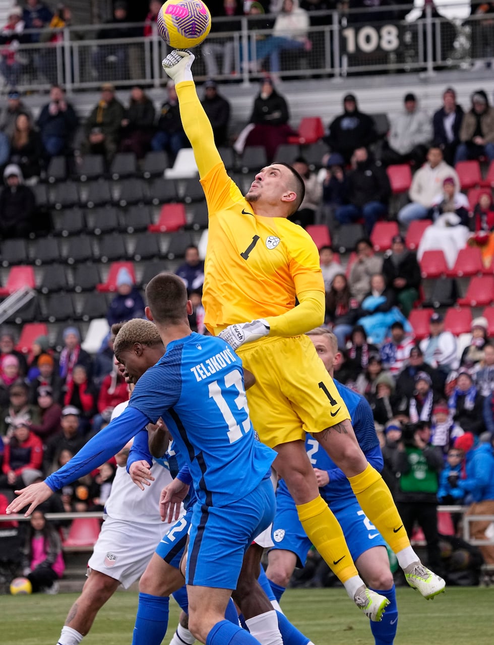 Slovenia goalkeeper Igor Vekic punches the ball away during the first half of an international...